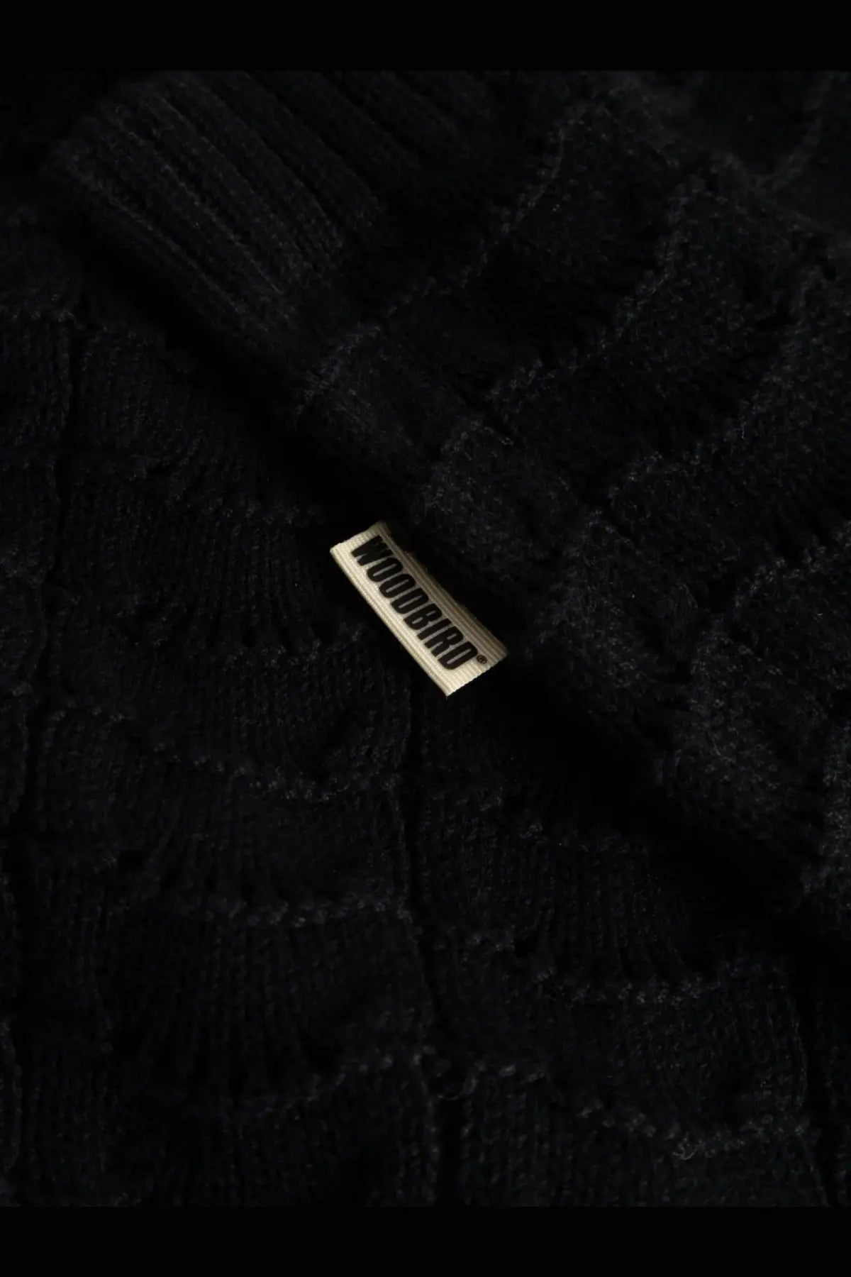 Black knitted cotton sweater with ribbed texture and metallic woodbird brand tag for men