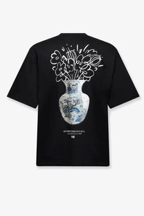 Back of a black woodbird men’s ming tee organic cotton shirt with a detailed white and blue floral vase graphic