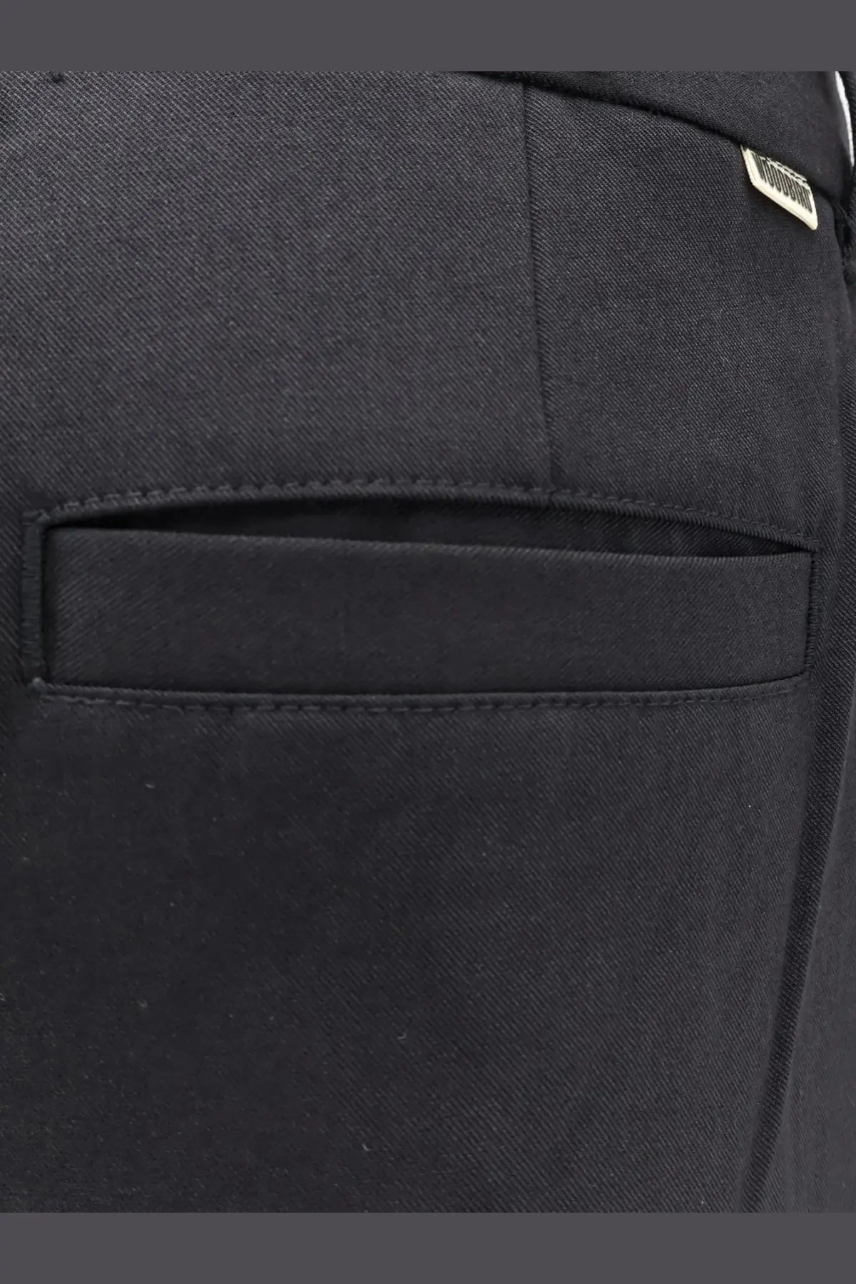 Black denim pocket of woodbird men’s viscose blend trousers with subtle woven texture and neat stitched edges