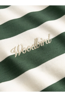 A cream-colored embroidered woodbird logo on a green and white striped organic cotton woodbird men’s tee
