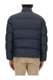 Woolrich men’s down jacket in cloud blue with dark blue quilted puffer design and high collar features horizontal stitching