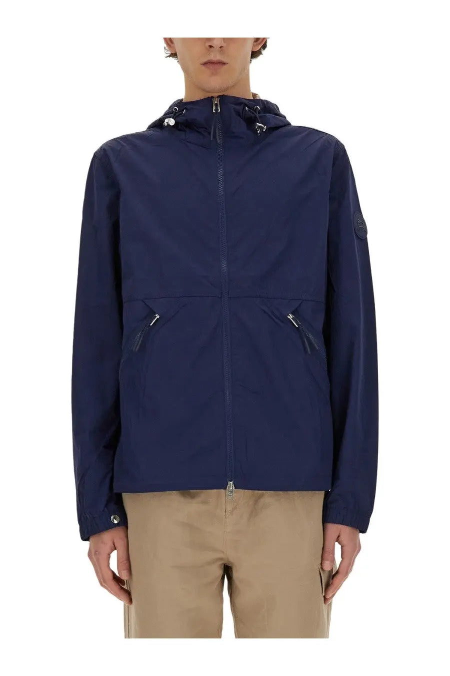 Woolrich men’s navy blue nylon hooded jacket with zippered pockets and subtle logo patch on the sleeve