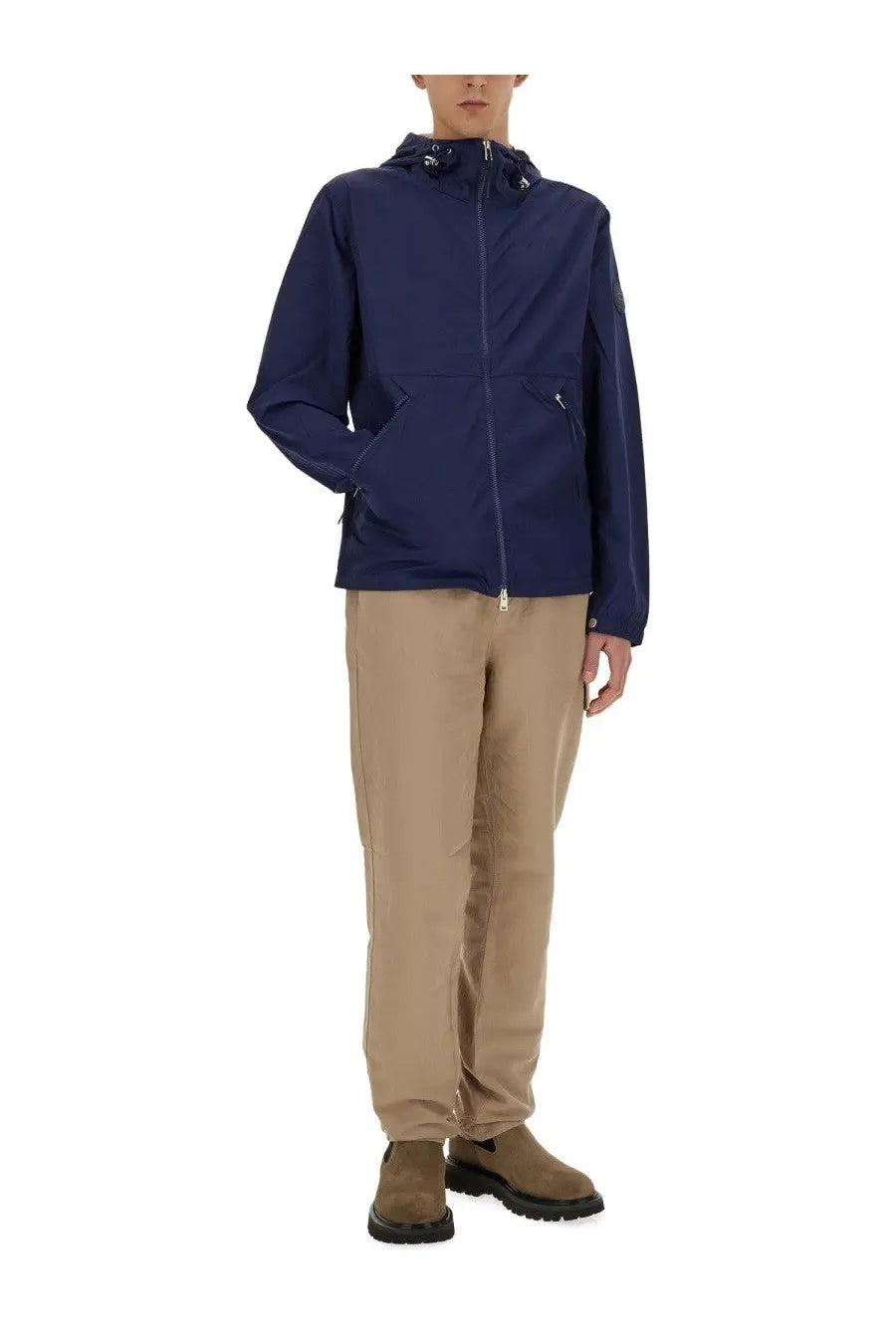 Woolrich men’s navy blue nylon hooded jacket with zippered pockets and subtle brand patch on the sleeve