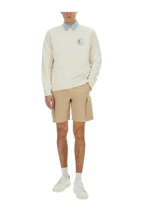 Woolrich men’s cream-colored long-sleeved sweatshirt with subtle embroidered logo paired with khaki cargo shorts