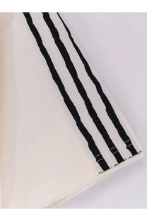 A cream-colored y-3 men’s cotton shirt with bold black vertical stripes and textured weave detailing