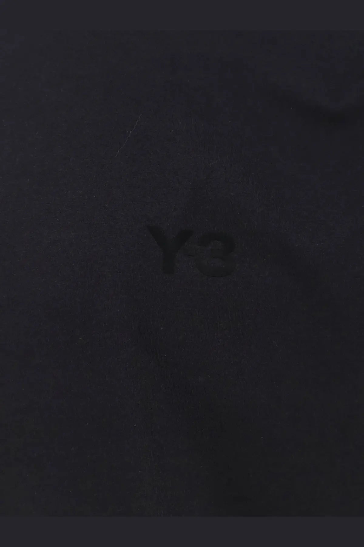 Black y-3 logo embroidered on dark fabric of y-3 men’s cotton shirt black highlighting the design detail