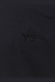 Black y-3 logo embroidered on dark fabric of y-3 men’s cotton shirt black highlighting the design detail