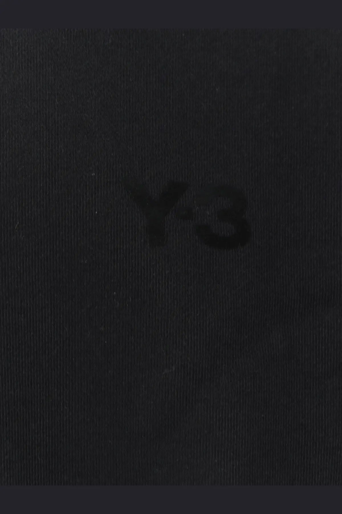 Black y-3 logo embroidered on dark textured fabric of y-3 men’s black cotton sweatshirt close-up