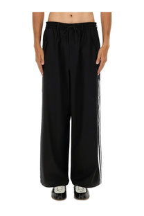 Black y-3 men’s jogger pants with wide-leg fit and three white stripes down the side for casual wear
