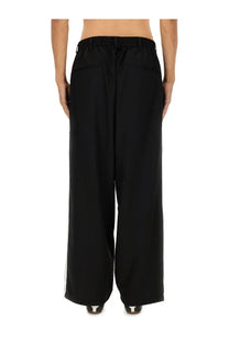 Y-3 men’s black jogger pants with wide-leg cut drawstring waistband and subtle white side stripes