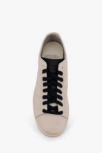 Cream-colored leather low-top y-3 men’s stan smith sneakers with black laces and subtle logo on the tongue