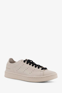 Cream-colored leather low-top y-3 men’s stan smith sneaker with black laces and minimalist design in beige