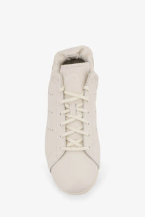 Cream-colored leather adidas y-3 men’s stan smith lo pro sneaker with matching laces and subtle side perforations