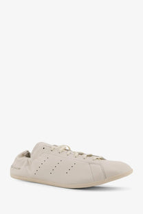 Cream-colored leather y-3 men’s stan smith lo pro sneaker with perforated side panels and matching laces in white
