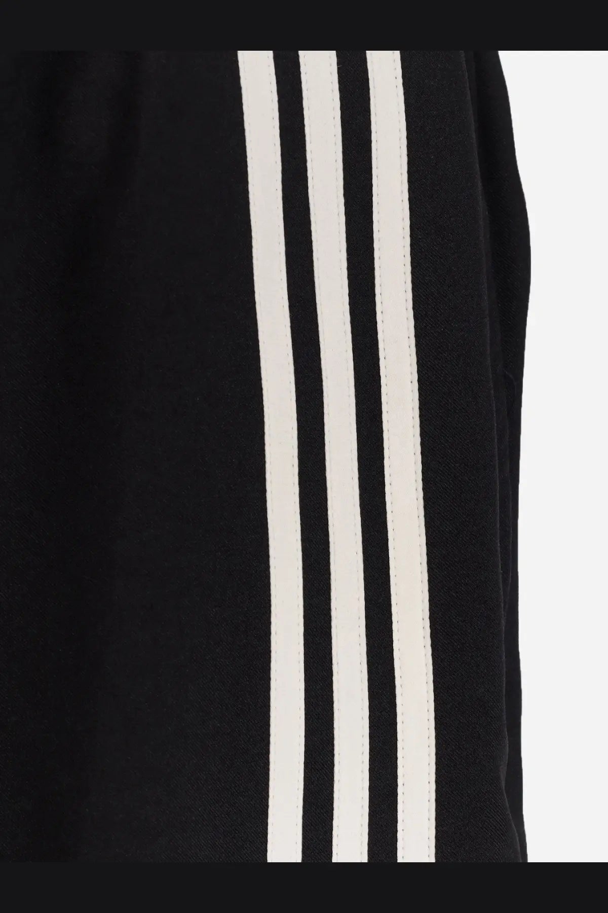 Black adidas y-3 men’s su bball recycled polyester track pants with three bold white stripes down the side