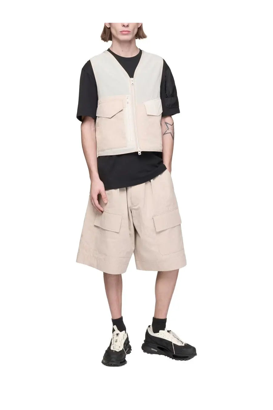 Y-3 men’s beige utility vest with front zipper and two chest pockets worn over a black t-shirt