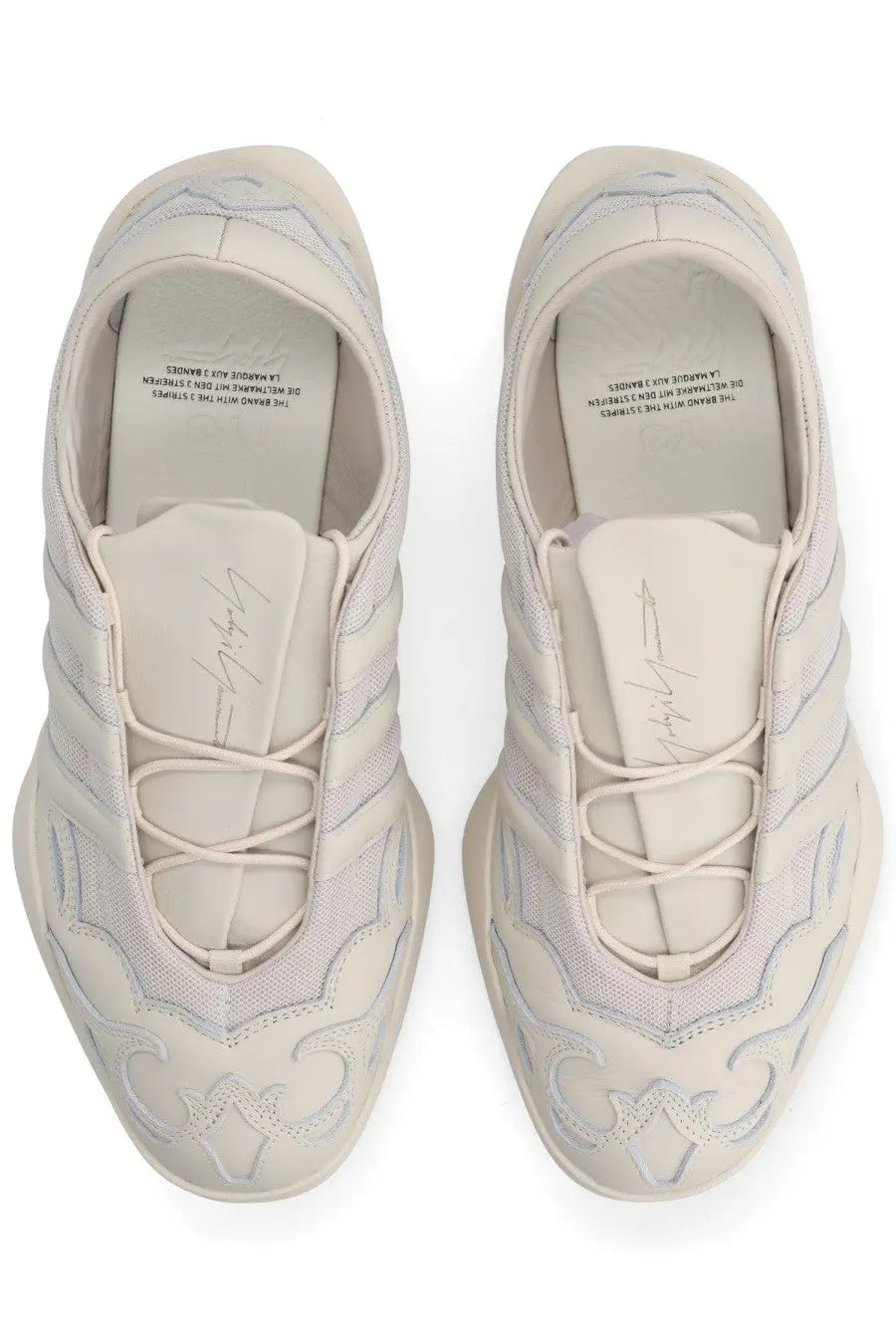 Cream-colored y-3 unisex regu sneaker with intricate embroidered patterns and sleek modern design in grey tones