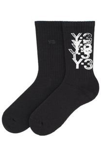 Black y-3 unisex crew socks with bold distressed white y-3 logo stacked vertically on the side for casual wear