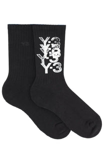 Black y-3 unisex crew socks featuring bold stacked white logo design in a comfortable cotton blend material