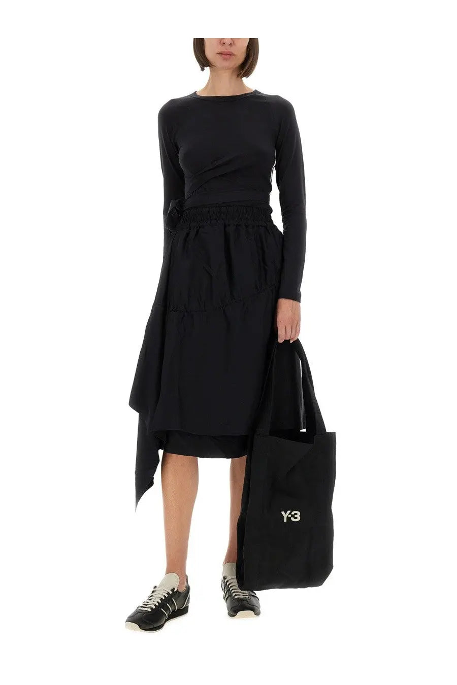 Black y-3 tote bag with white logo made of durable fabric paired with y-3 women’s asymmetrical black skirt