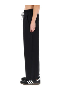 Black adidas Y-3 women’s jogging pants with a drawstring waist and three white stripes down the side