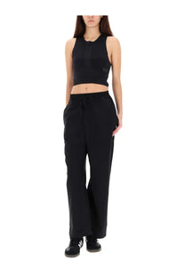 Black y-3 crop top with subtle logo on left chest and elastic waistband paired with women’s black jogging pants