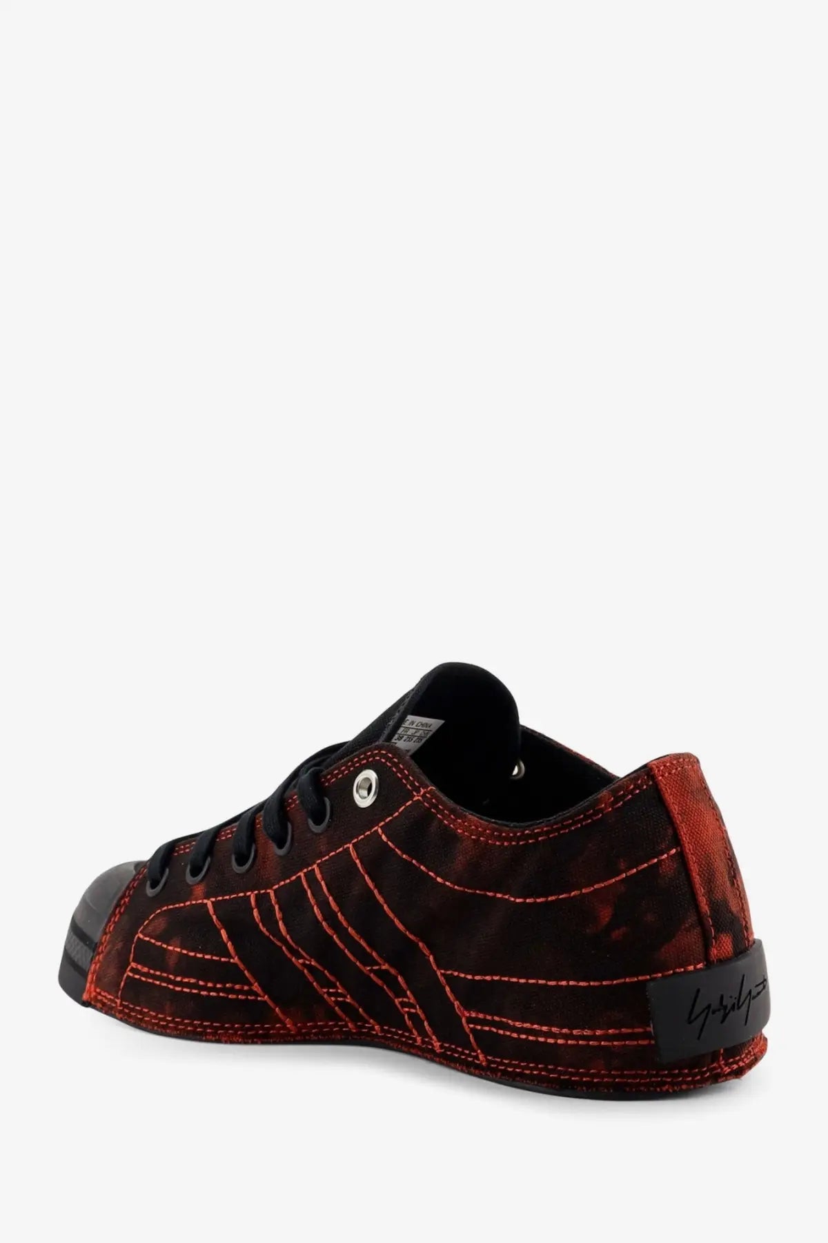 Back side of y3 women’s nizza lo canvas sneakers black in red and black suede with bold red stitching and brand label