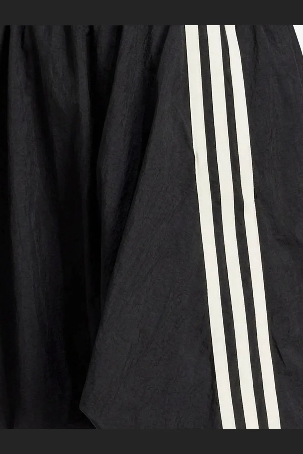 Black y-3 women’s nylon skirt with three bold white stripes down the side made from lightweight textured fabric