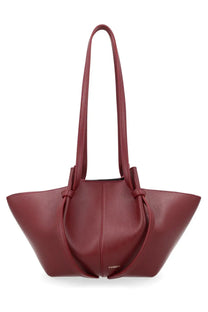 A sleek burgundy leather tote bag with structured soft silhouette and adjustable shoulder straps by Yuzefi