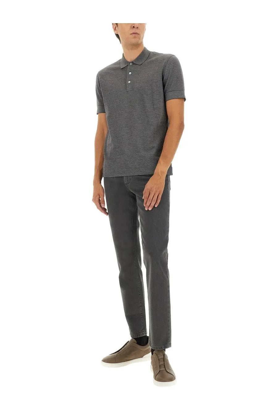 A man wearing a zegna men’s grey cotton blend polo shirt with white buttons and matching charcoal-gray trousers