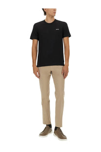 Black short-sleeved t-shirt with a small white logo on the left chest paired with zegna men’s premium cotton beige pants