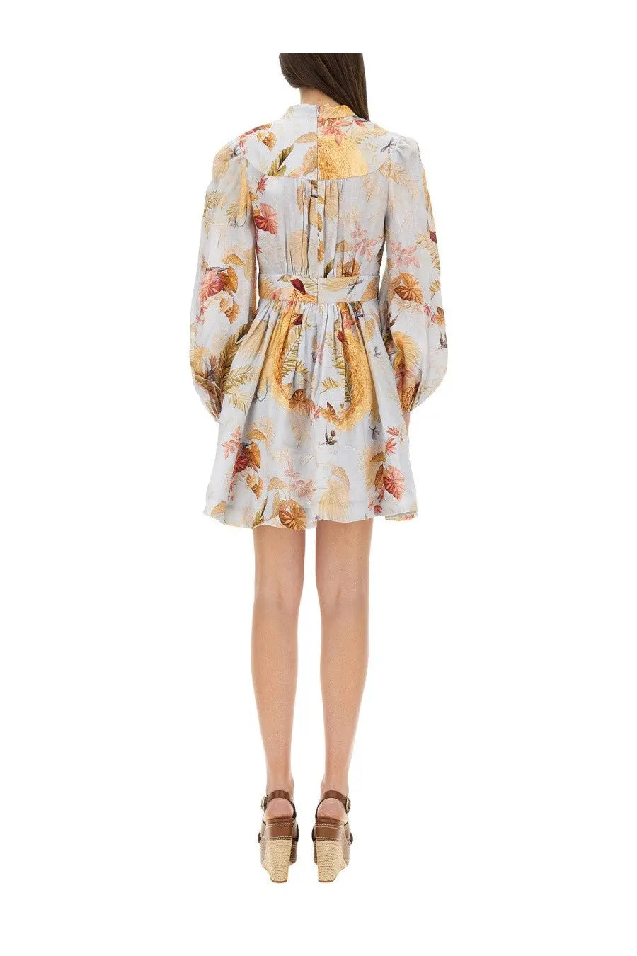 A woman wears a light-colored Zimmermann women’s Ascension dress blue floral long-sleeved fitted waist flared skirt
