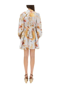 A woman wears a light-colored Zimmermann women’s Ascension dress blue floral long-sleeved fitted waist flared skirt