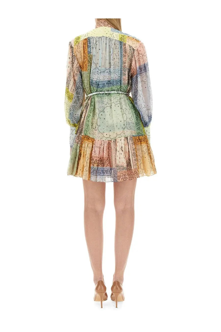 A woman wearing a Zimmermann women’s multicolor mini dress with long sleeves and pastel paisley patchwork patterns