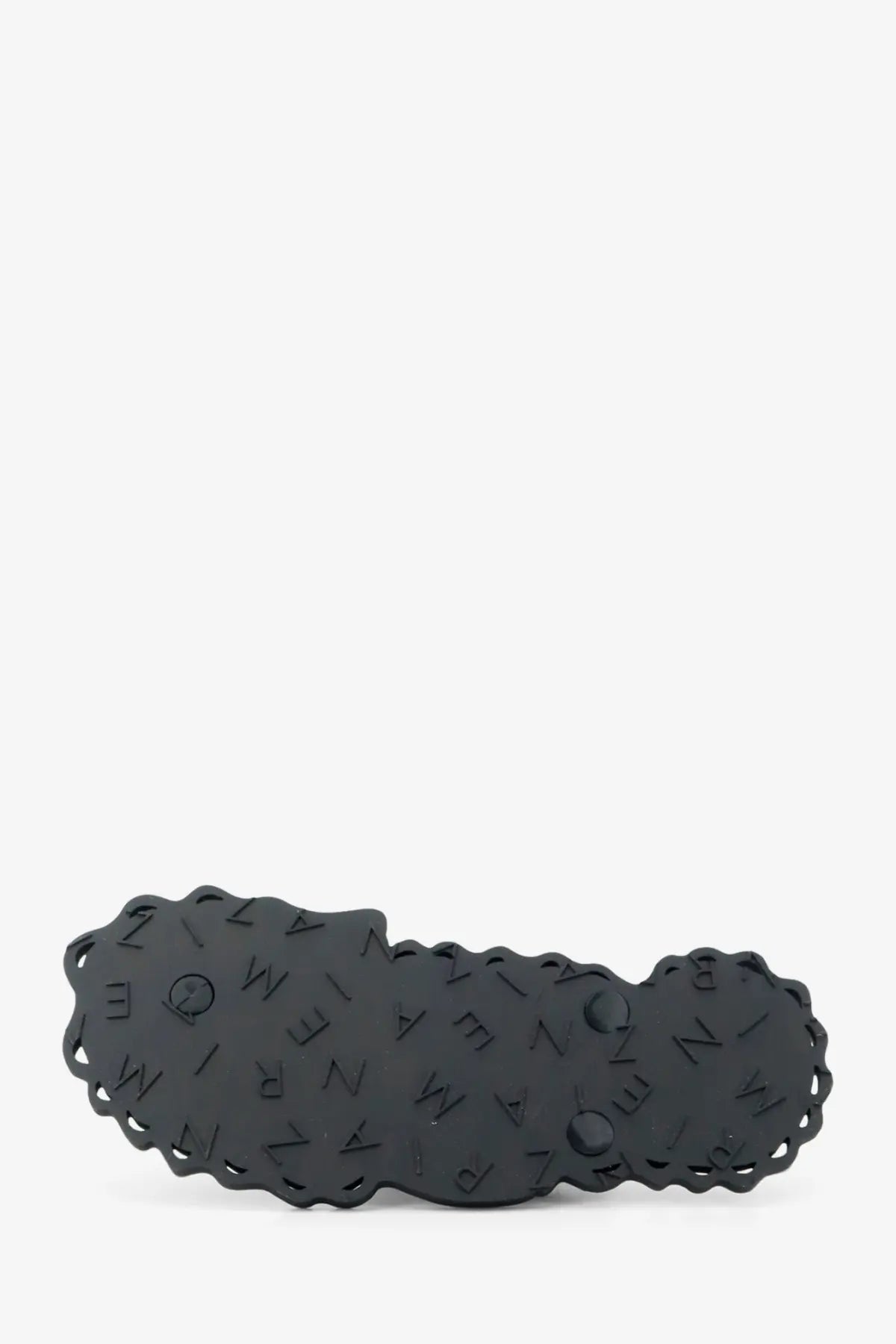 Black glossy plastic hair clip with scalloped edge and embossed lettering shown with zimmermann seafoam thong sandals